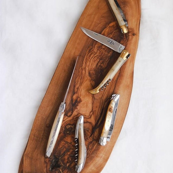 Set of corkscrew tools on a wooden board with a white background
