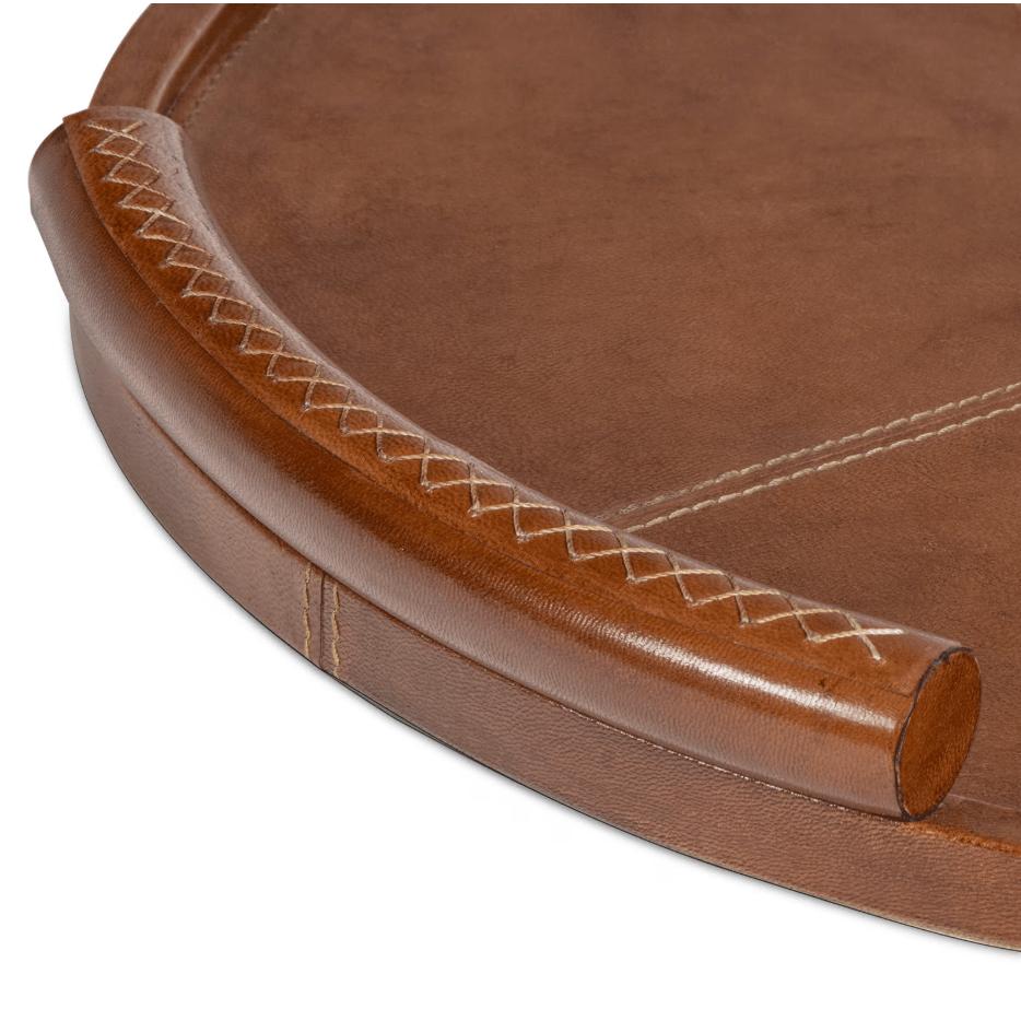 Round cognac leather tray with baseball stitching on the platform and lace-stitched oversized handles.