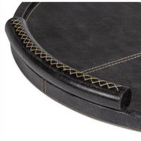 Round black leather tray with baseball stitching and lace-stitched oversized handles.