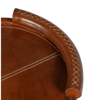 Cognac oval leather tray with intricate baseball stitching on the platform and lace stitching on oversized handles.