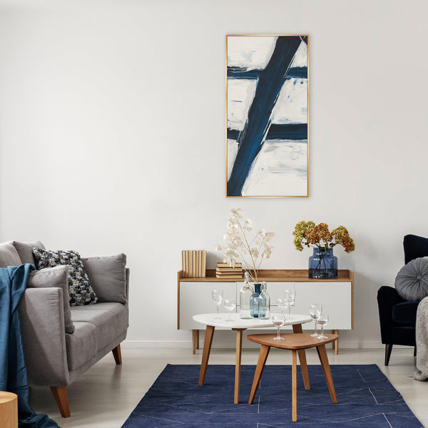 Abstract "Free Falling I" giclee canvas painting with bold blue and white strokes in a gold frame, styled in a modern living room.