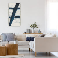Abstract giclee canvas painting with bold navy blue and white brushstrokes, framed in a modern living room.