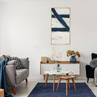 Abstract Free Falling II giclee canvas painting with bold blue and white strokes in a gold frame, hanging above a modern console table.