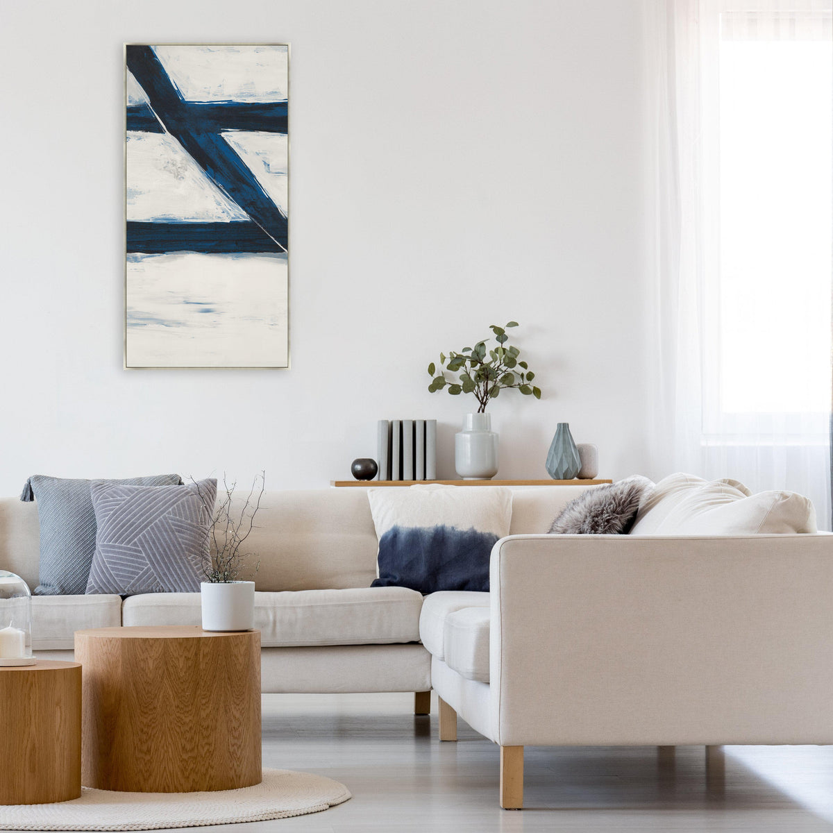 Abstract Free Falling II Giclee Canvas Painting with bold blue strokes on white, framed above a neutral sectional sofa.