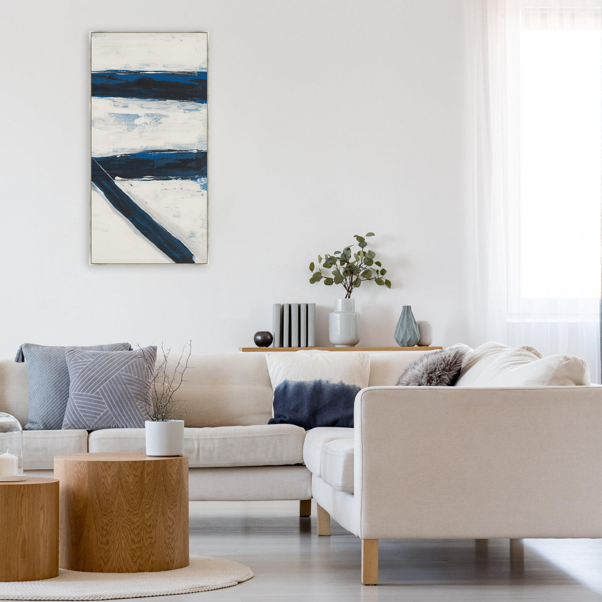 Abstract vertical giclee canvas painting with bold navy blue and white brushstrokes, displayed in a modern living room.