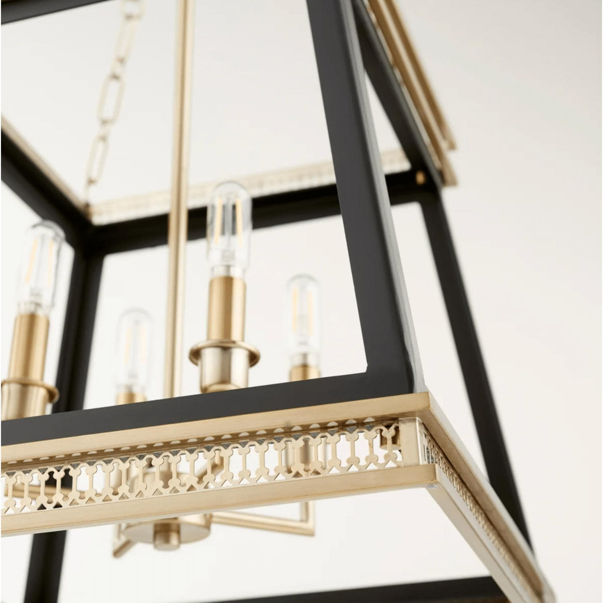 Gerome black and aged brass pendant with open frame, candelabra lights, and decorative trim.