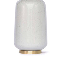 Glace ceramic table lamp with natural hues, a natural brass base, and a linen shade.