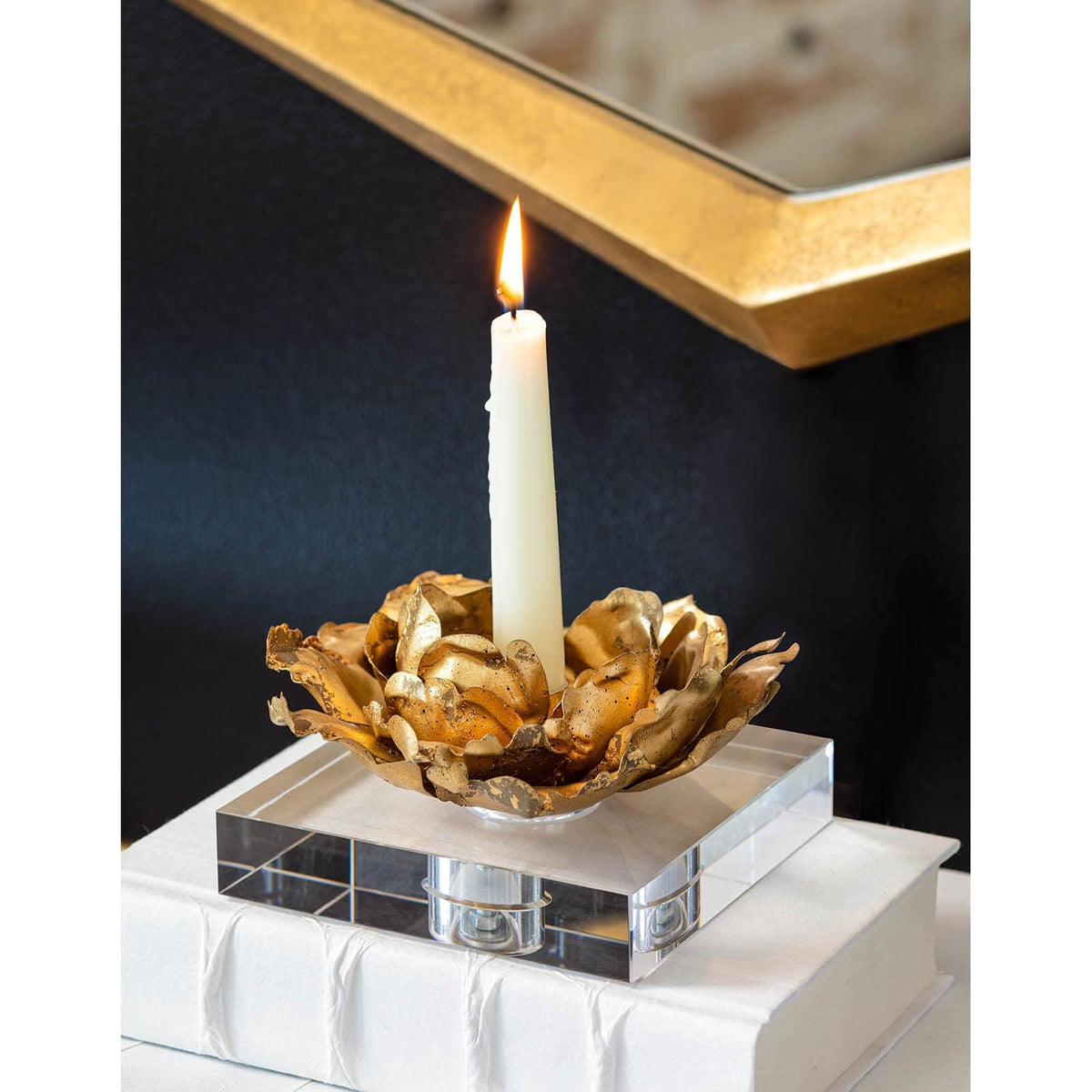 Gold leaf blossom candle accessory on a crystal base with a white tapered candle.