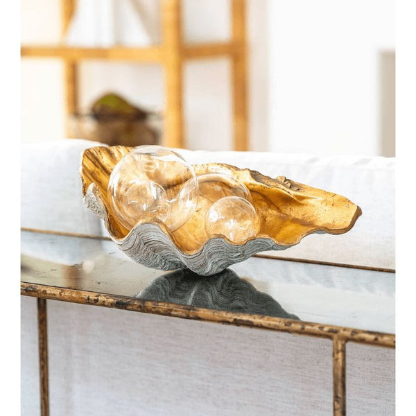 Golden Clam Bowl Small: Decorative clam shell with a gold interior and ribbed exterior, holding three clear glass orbs.