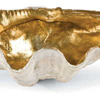 Small decorative clam shell bowl with a textured white exterior and a shimmering gold interior.