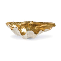 Small decorative clam shell bowl with a textured white exterior and a shimmering gold interior.