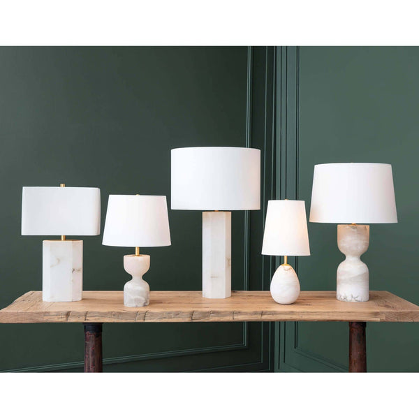 Five Grace Alabaster Table Lamps with white linen shades and natural brass hardware on a rustic wooden table.