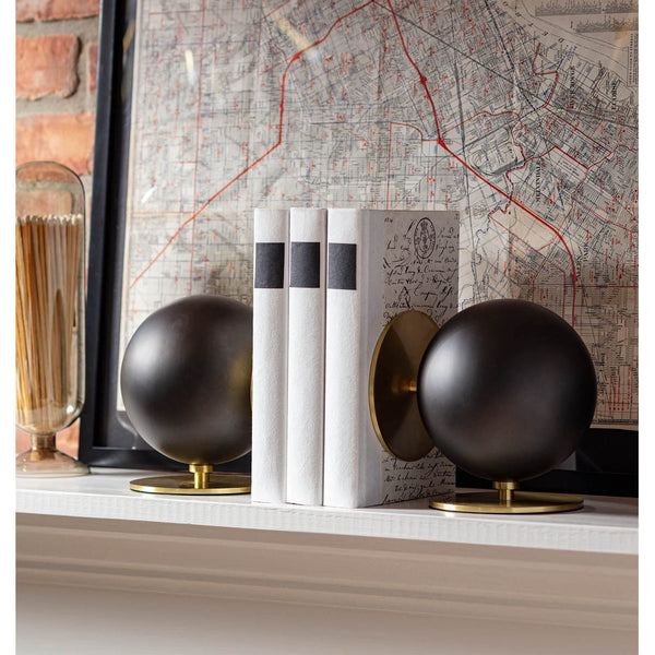 Grant Black & Brass Bookends: Modern spherical black metal bookends with natural brass disc bases holding white books.