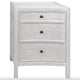 White distressed mahogany nightstand with three drawers and brass knobs.