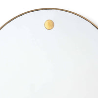 Close-up of a 36" circular mirror with a slender natural brass frame and a visible brass hanging stud.