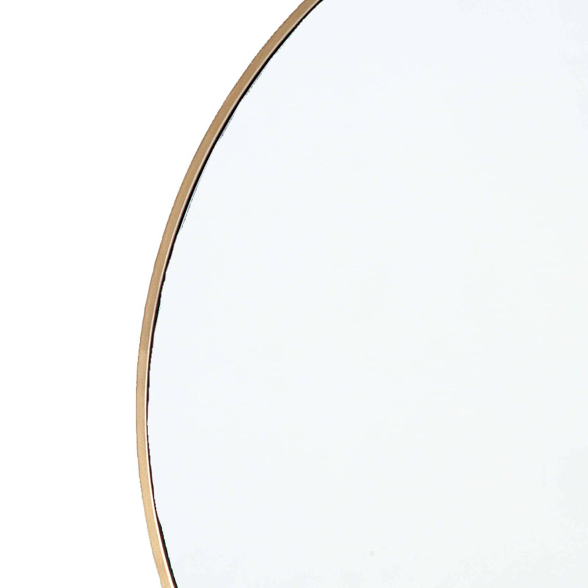 Close-up of a hanging circular mirror with a slender natural brass frame.