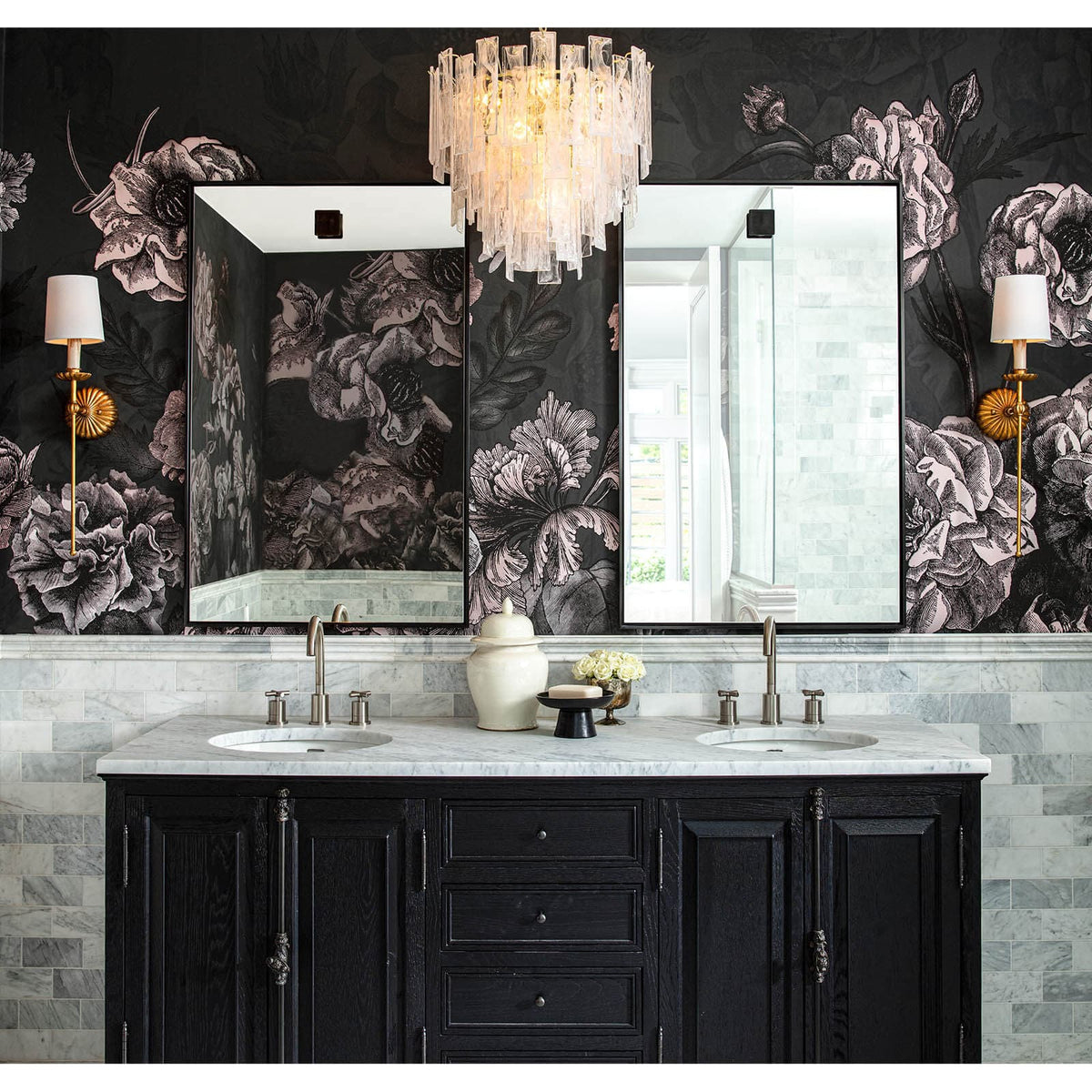 Two hanging rectangle steel mirrors over a black vanity with marble countertops and floral wallpaper.