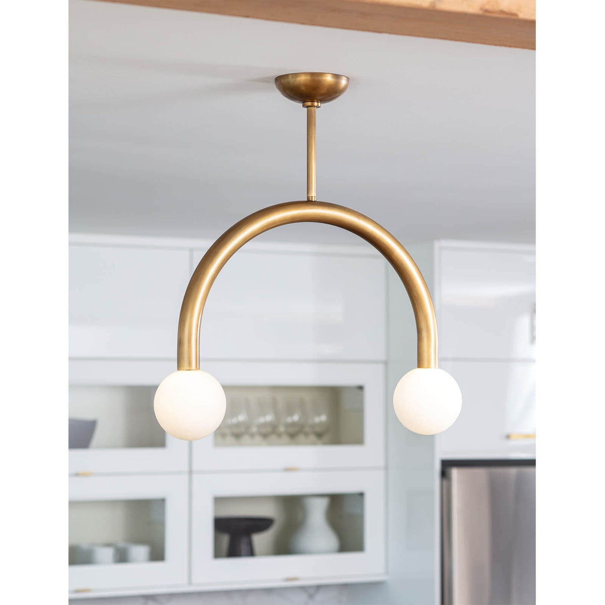 Happy Pendant Small Natural Brass light fixture with two matte white glass globes.