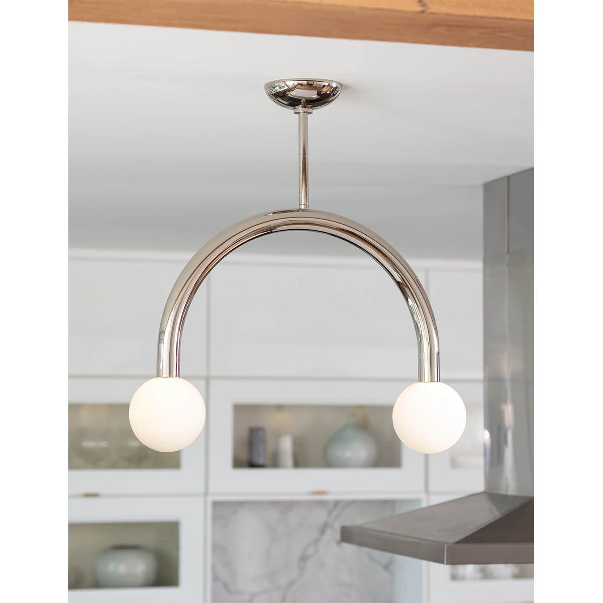 Happy Small Polished Nickel pendant light with a curved metal frame and two matte white glass globes.