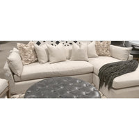 Hayberry slipcover sectional in a linen-polyester blend with a chaise, throw pillows, and grey tufted ottoman.