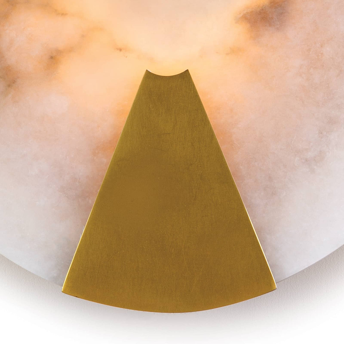 Houston sconce: round natural alabaster with warm light and natural brass framing.