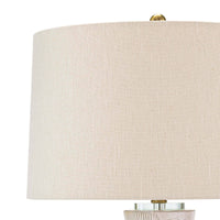 Hugo ceramic table lamp with a natural linen shade and polished brass accents.