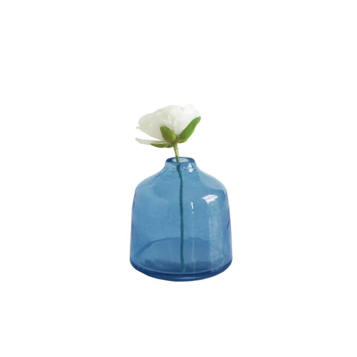 Blue glass vase with a white flower on a white background