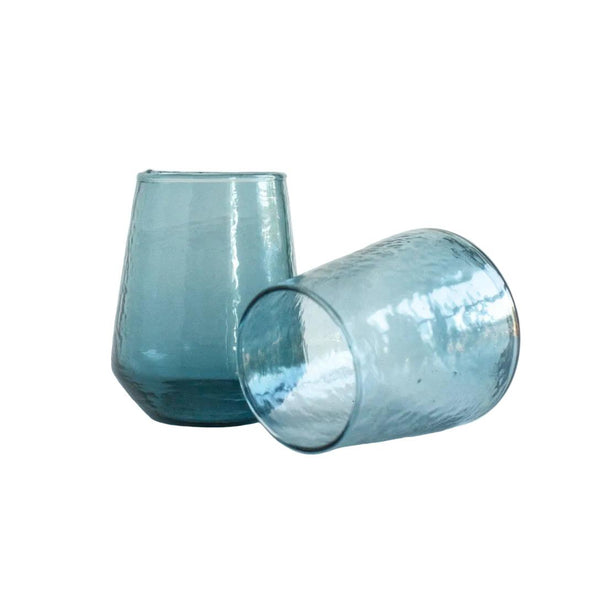 Two turquoise blue glass tumblers on a white background