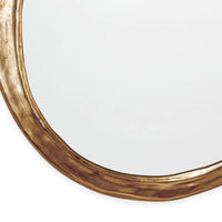 Ibiza Mirror with an organic, undulating circular shape and antique gold finish.