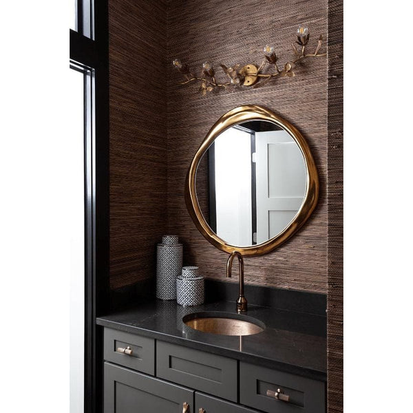 Ibiza Mirror Antique Silver: Organic, undulating circular mirror with a warm, ambered silver glow in a bathroom.
