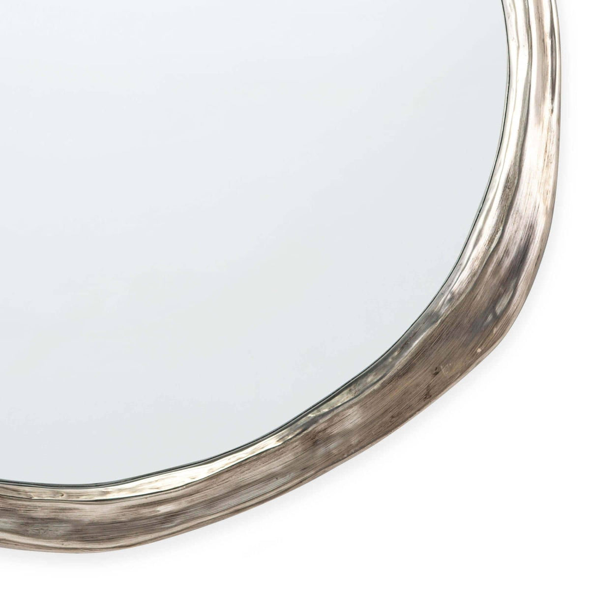Ibiza Mirror: organic, undulating circular shape with an antique silver frame and warm, ambered glow.