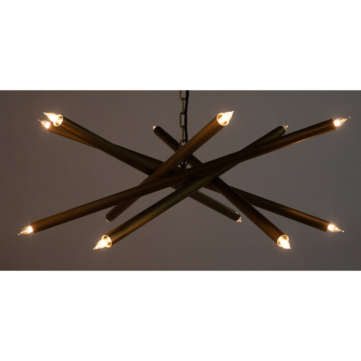 Ikram Small Chandelier with antique brass finish metal tubes and exposed bulbs.