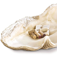Large, off-white resin Imperial Clam replica bowl with textured details, holding wine corks and paper.