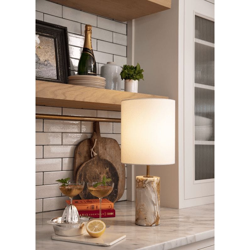 Elegant jade and brass mini cylinder lamp with a natural linen drum shade on a marble countertop.