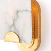 Jonah alabaster sconce with a white marble slab, natural veining, and a raw broken edge, mounted on a gold frame.