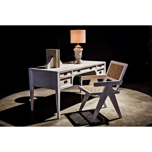White wash Jude Chair with caning back and seat, next to a matching desk with brass pulls and a lamp.