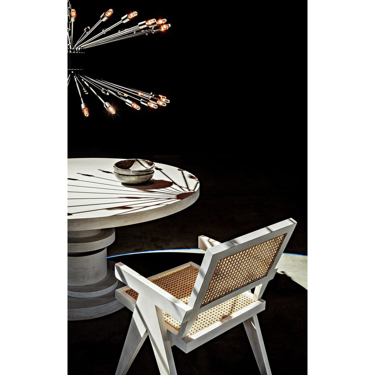 White wash Jude Chair with caning seat and back, beside a round white table.