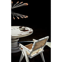 White wash Jude Chair with caning seat and back, beside a round white table.