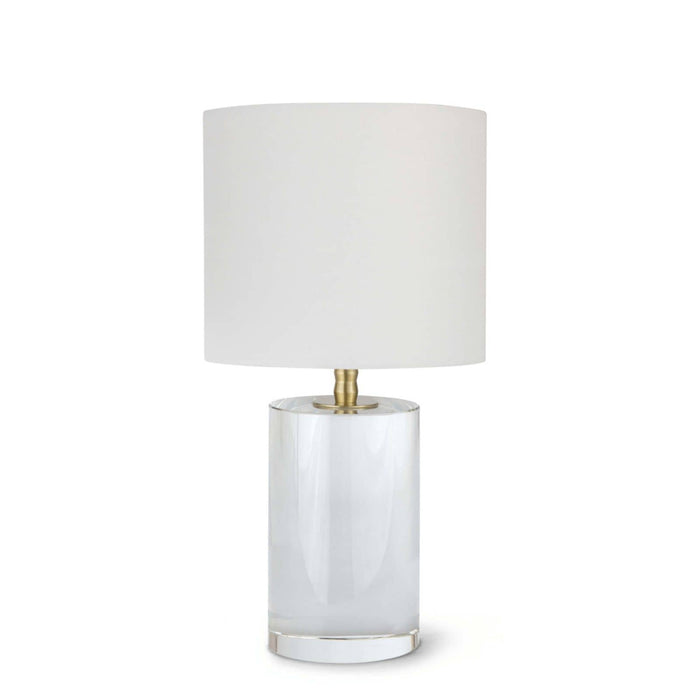 Small Juliet crystal table lamp with a clear cylindrical base, natural brass hardware, and a white linen drum shade.
