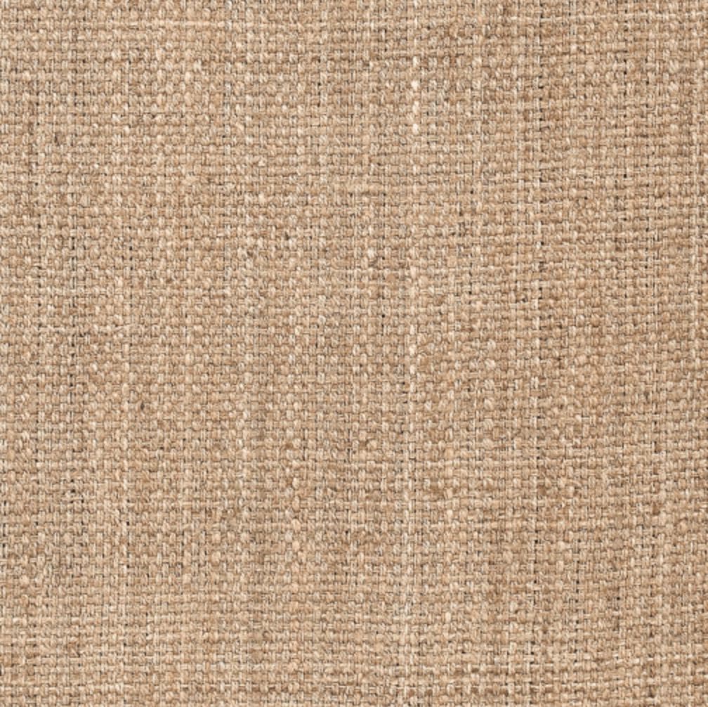 Close-up of a tan, hand-woven jute rug with a visible natural fiber texture.