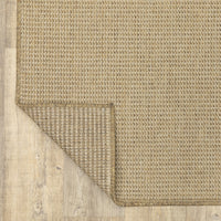 Karavia Sand outdoor rug, woven polypropylene with a natural seagrass look, corner folded to show backing.