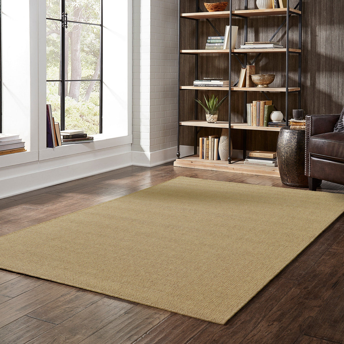 Karavia Tan Outdoor Rug, a durable polypropylene power-loomed rug with a natural seagrass look on a wood floor.