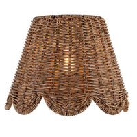 Kismet Sconce with a woven rattan-like shade, scalloped bottom edge, and warm glow.