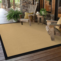 Lanai Beige & Black Outdoor Rug with natural Sisal-inspired weave on a wooden deck.