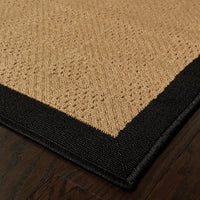 Lanai Beige & Black Outdoor Rug with natural Sisal-inspired weave and black border on wood floor.