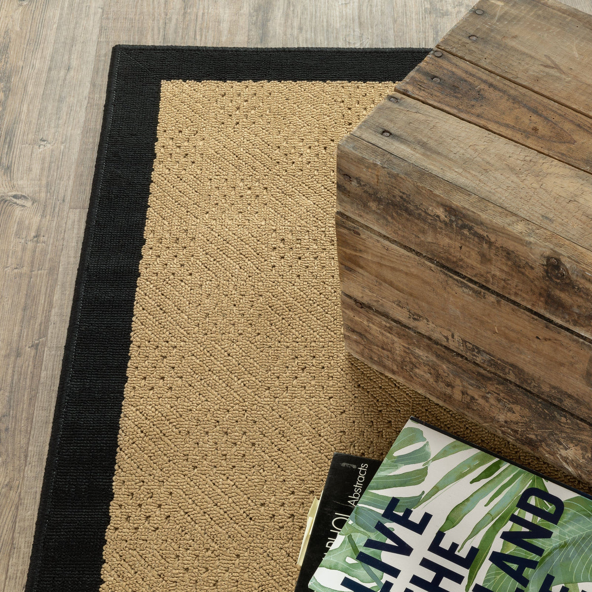 Lanai Beige & Black Outdoor Rug with textured polypropylene weave, next to a rustic wooden table.