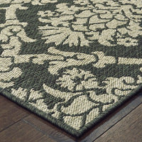 Latitude Grey & Charcoal outdoor rug with a traditional floral pattern on dark wood flooring.