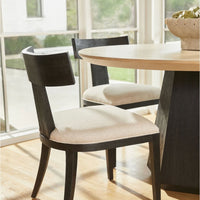 Liam natural oak round dining table with a sunburst top and black oak faceted base.