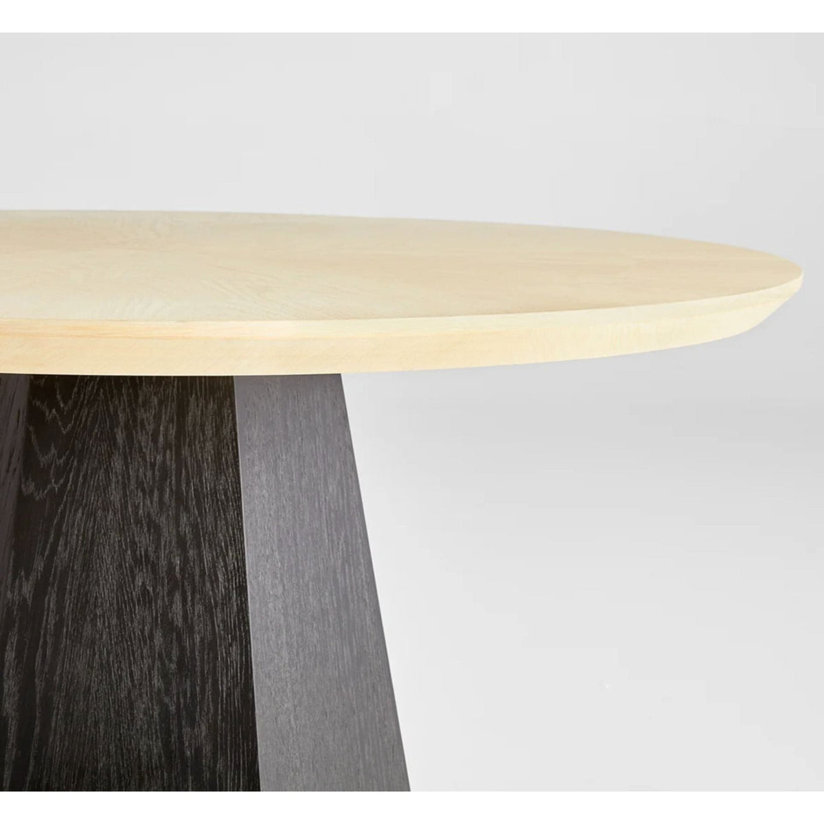 Liam natural oak round dining table with sunburst top and faceted black oak base.