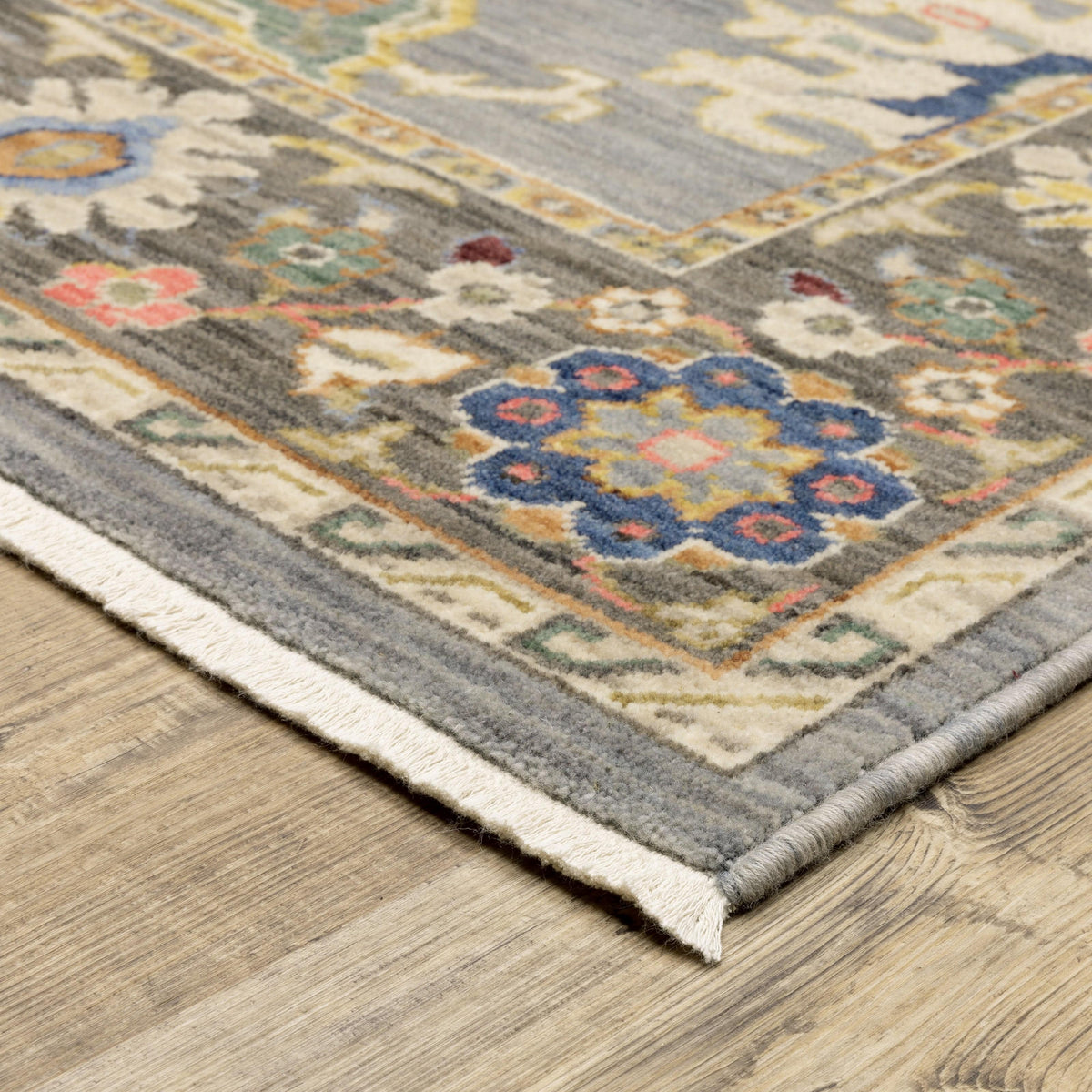 Lucca Blue & Multi Traditional Rug with intricate floral patterns, space-dyed wool/nylon, and fringed edge on wood floor.